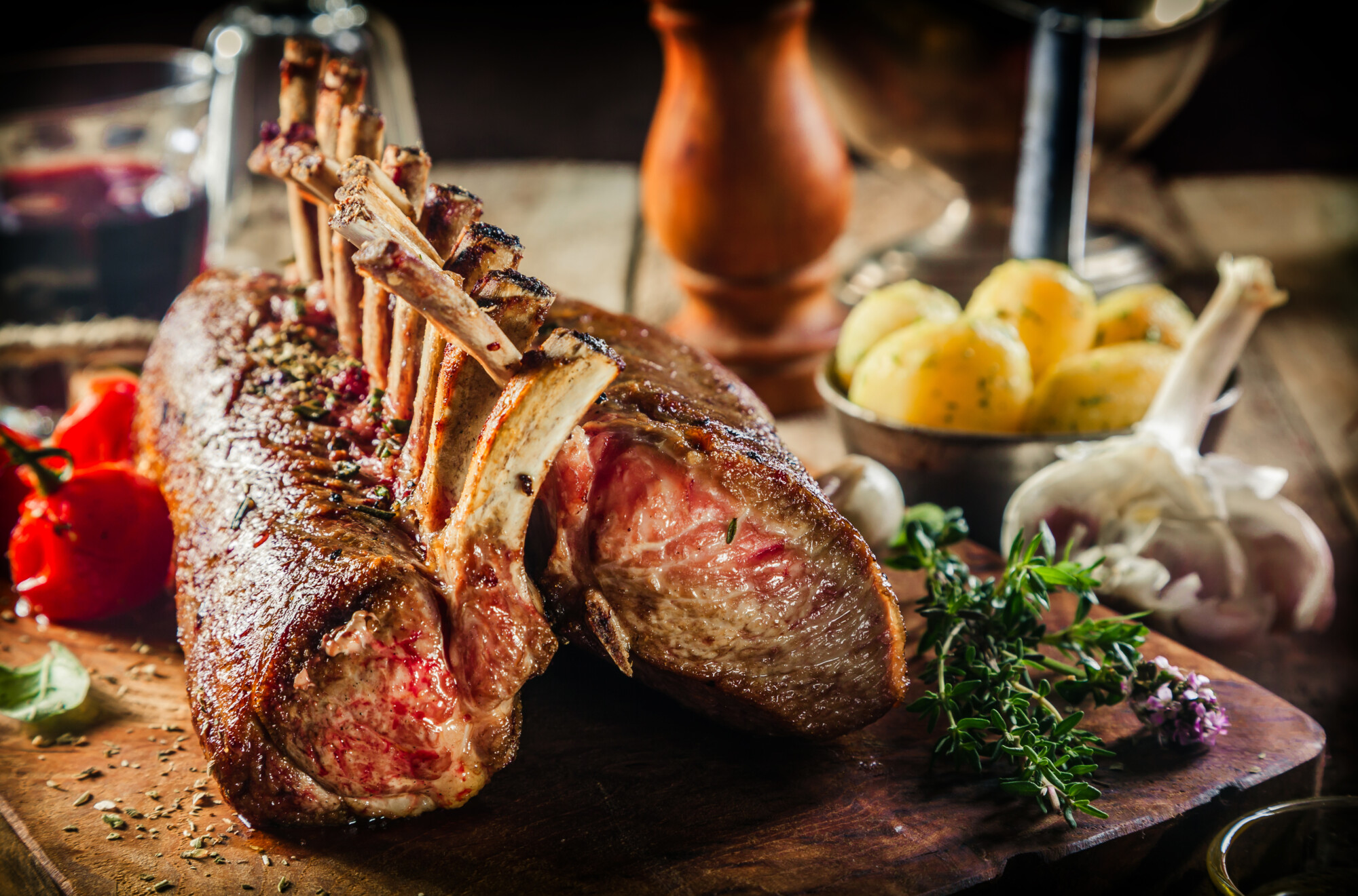 love lamb campaign - Roasted Rectangle Rack of Lamb Chops on Wooden Cutting Board Surrounded by Herbs and Fresh Ingredients