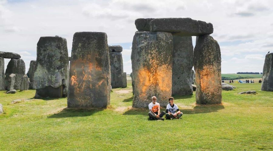 just stop oil activists sitting in front of Stonehenge, with orange spray paint on it