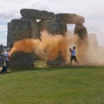 activists spraying Stonehenge with orange paint