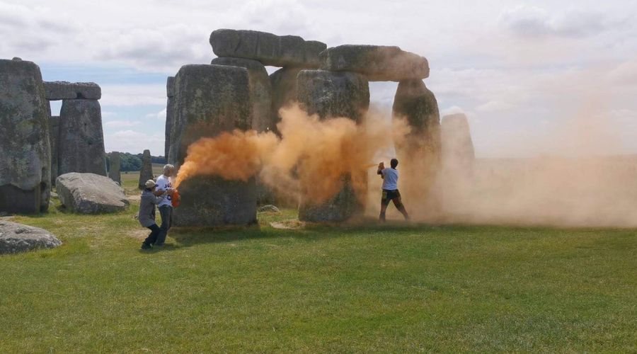 activists spraying Stonehenge with orange paint