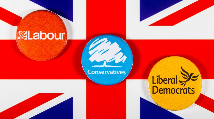 Union Jack with labour, conservative and Lib Dem badges on top