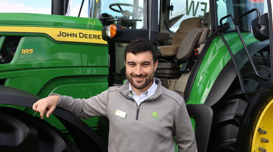 John Deere tractor product specialist Tomos Lloyd with John Deere 6M-series tractor