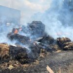 Firefighters have tackled a large hay bale blaze involving 15 tonnes of straw, a lorry and trailers on the Essex-Suffolk border. 