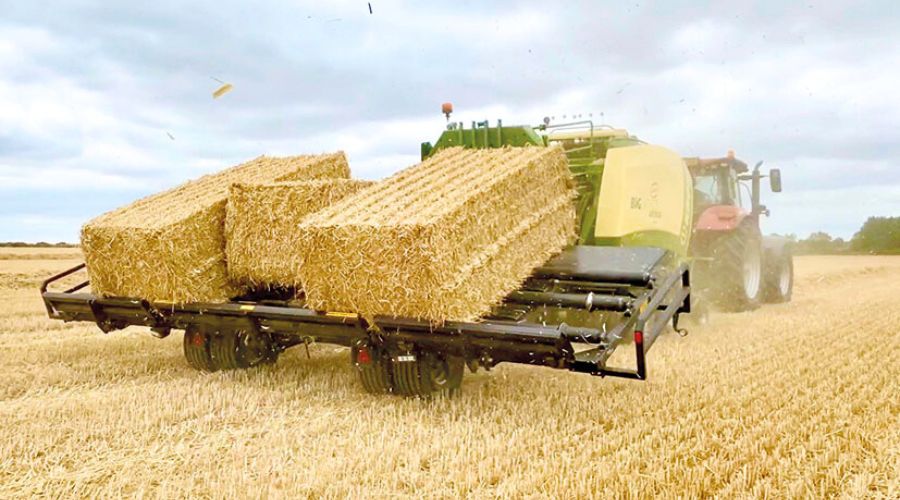 Bales being transported on farm in guide to baling safety article