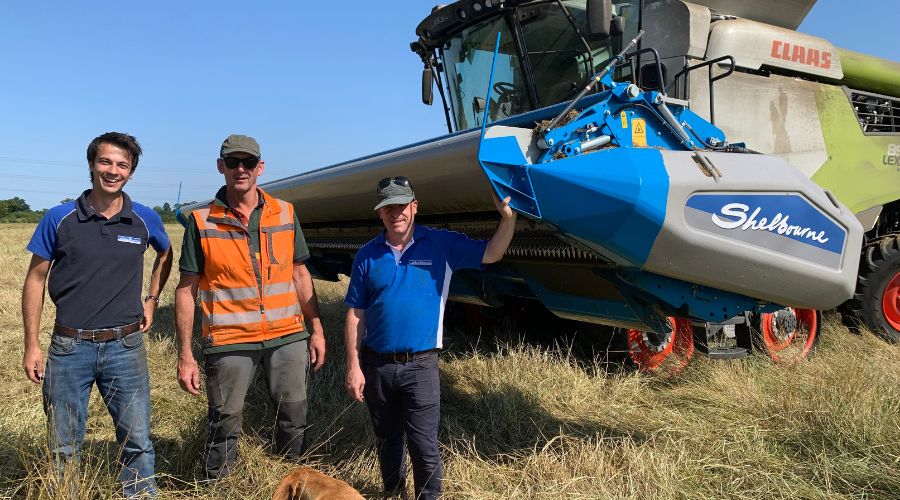 Farm foreman Rob Hale (centre) with Shelbourne Reynolds design engineers Harry Garrett (left) and Charles Gibbs (right). All are standing in front of a Claas combine with Shelbourne Reynolds stripper header.