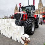 Massey Ferguson Tractor with houses of parliament in the background, and a #Back British Farming sign in the foreground