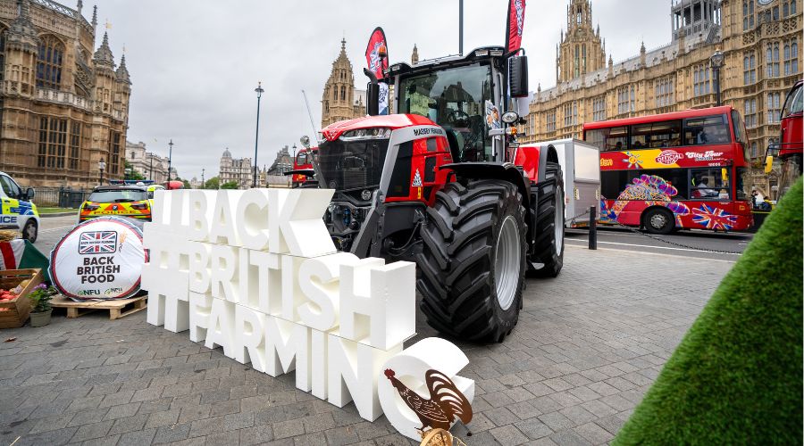 Massey Ferguson Tractor with houses of parliament in the background, and a #Back British Farming sign in the foreground