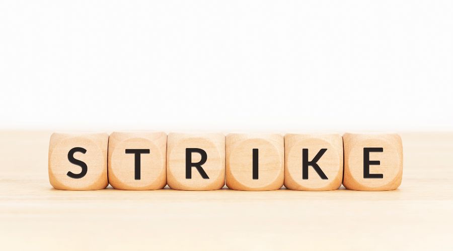 the word 'strike' written on wooden cubes in a line