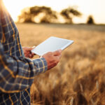 farmer using a tablet for business in a field