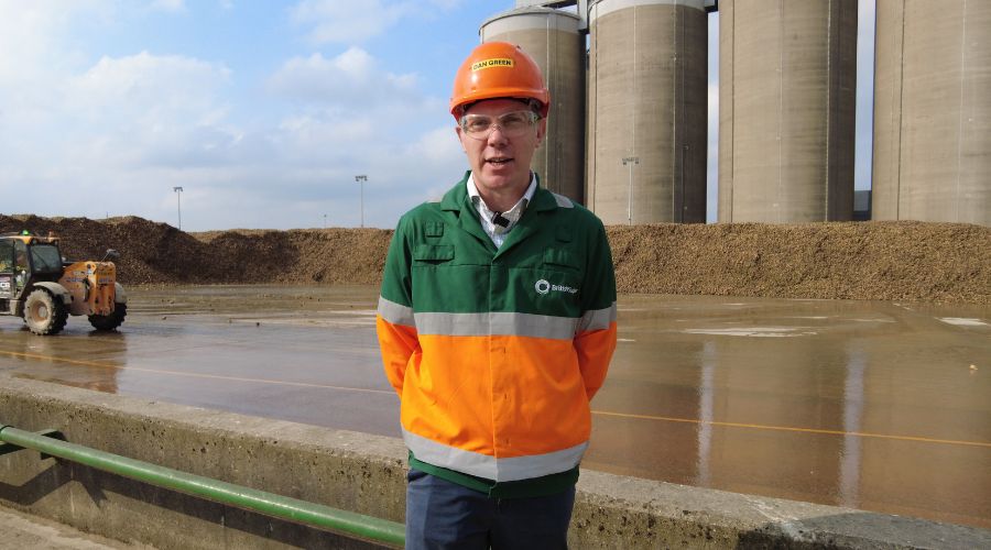 Dan Green, agriculture director at British Sugar, standing in front of factory wearing orange hard hat and orange and green uniform