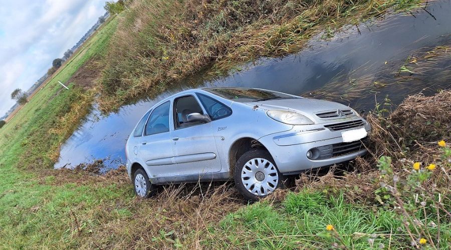 silver car parked next to a water filled ditch