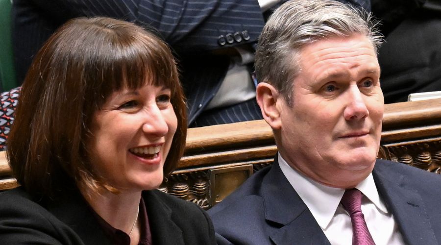 chancellor Rachel Reeves laughing and sitting next to keir starmer in the House of Commons