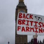 farmer holding a sign up saying Back British Farming, with big ben in the background