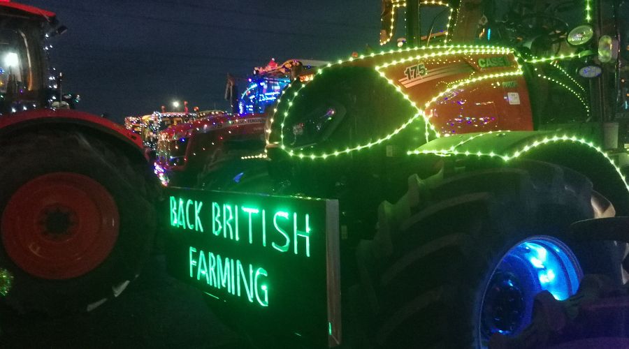 tractor with festive lights and 'Back British farming' written in neon green on the front 