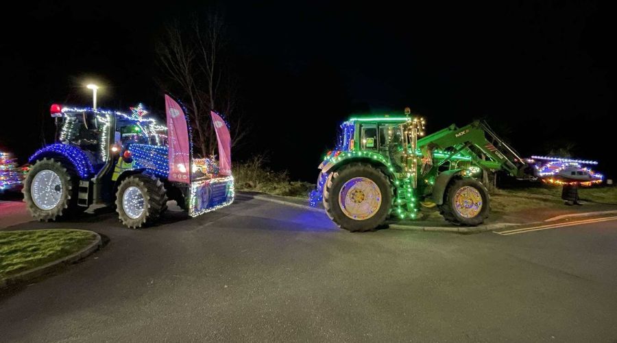 Two tractors setting off on the tractor run, one with blue lights, the other green, covering them