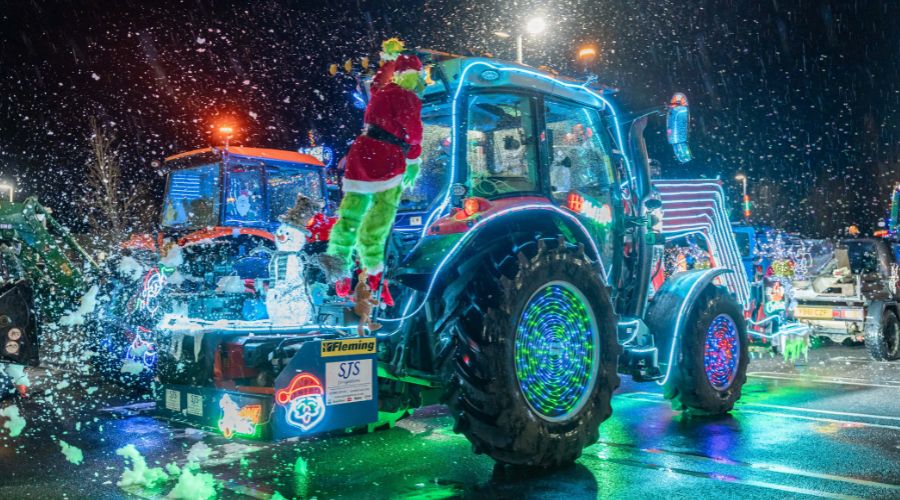 tractor covered in lights with The Grinch hanging onto the back