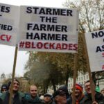 farmers protesting in London holding placards saying Reeves Not Qualified, Starmer the Farmer Harmer and No Tax on Assets Scrap All Ag Taxes