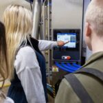 three students looking at a Delaval milking system screen